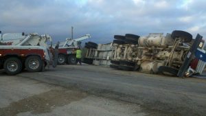 roadside assistance for a tractor trailer turned over on the side of the road