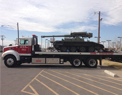 tank loading onto bed of heavy hauling truck